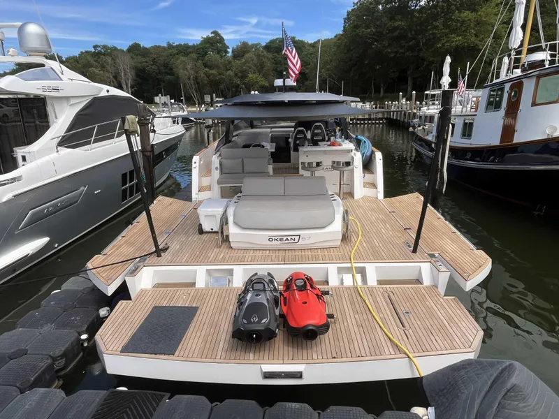 Slide: The Image of 2023 OKEAN 57 yacht docked, featuring spacious deck and modern design. - 14