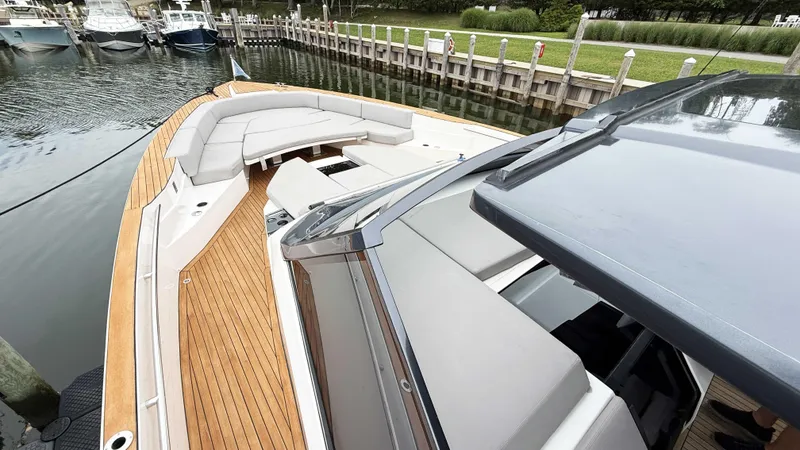 Slide: The Image of 2023 OKEAN 57 yacht with sleek design, spacious deck, and luxurious seating at a marina. - 16