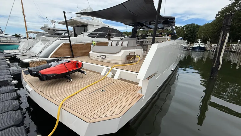 Slide: The Image of Luxury 2023 OKEAN 57 yacht docked, featuring sleek design and spacious deck. - 21