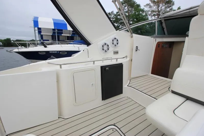 Slide: The Image of 2006 Cruisers Yachts 320 Express interior with seating and storage, docked near water. - 10