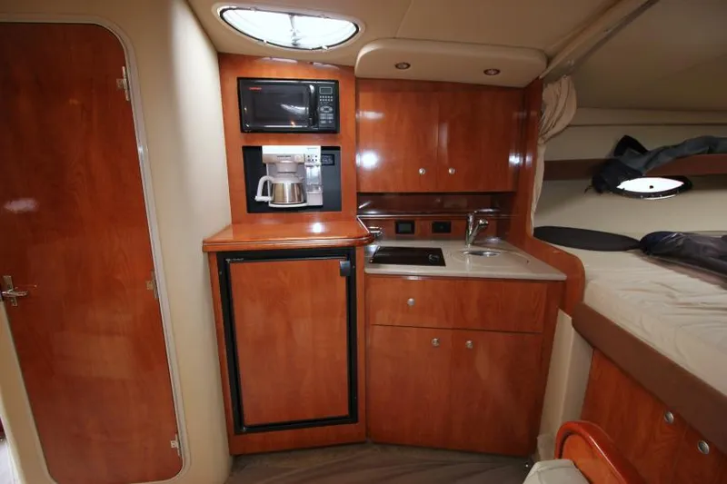 Slide: The Image of 2006 Cruisers Yachts 320 Express interior with kitchenette, featuring microwave, coffee maker, and sink. - 20