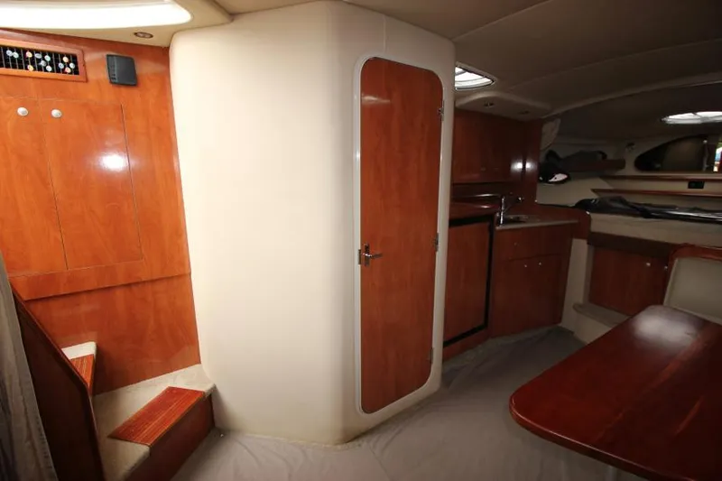 Slide: The Image of Interior of 2006 Cruisers Yachts 320 Express, featuring wood cabinetry and compact kitchen area. - 28