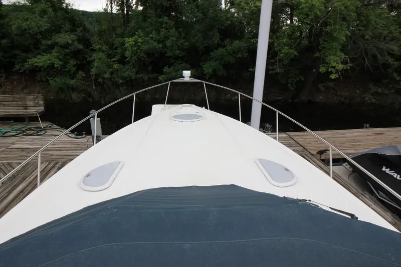 Slide: The Image of 2006 Cruisers Yachts 320 Express boat docked, view from bow, surrounded by greenery. - 30