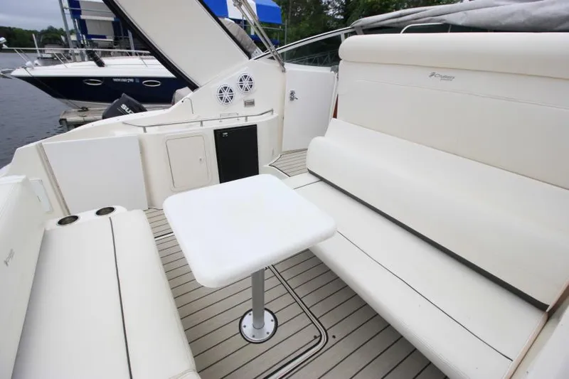 Slide: The Image of 2006 Cruisers Yachts 320 Express interior with white seating and table on deck. - 9