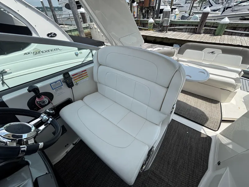 Slide: The Image of 2013 Monterey 280 SCR boat interior with white seating and steering wheel. - 14