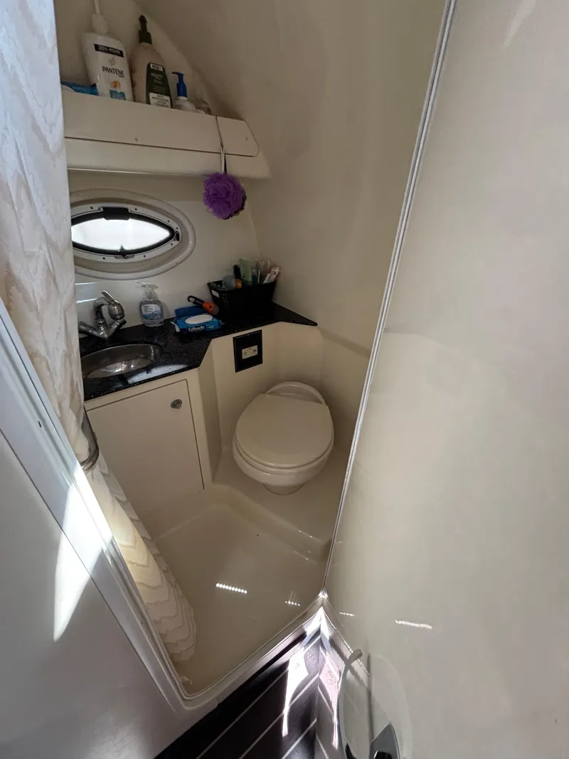 Slide: The Image of Compact bathroom in a 2013 Monterey 280 SCR boat, featuring a sink and toilet. - 16