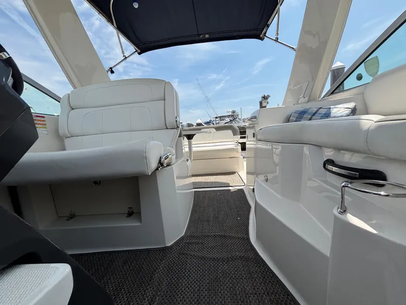 Slide: The Image of 2013 Monterey 280 SCR boat interior with white seating and blue canopy. - 20