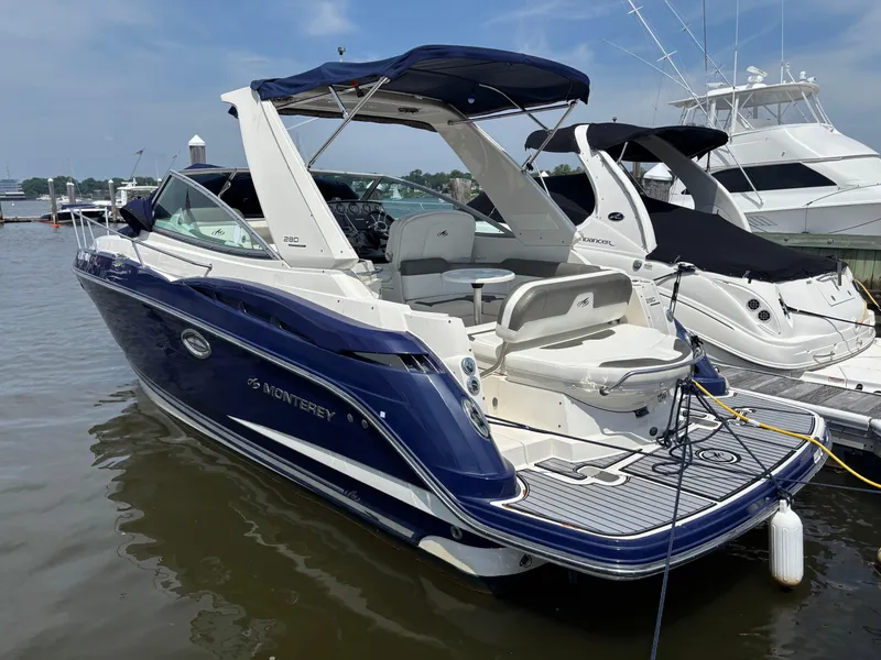 Slide: The Image of 2013 Monterey 280 SCR boat docked, featuring sleek blue and white design. - 6