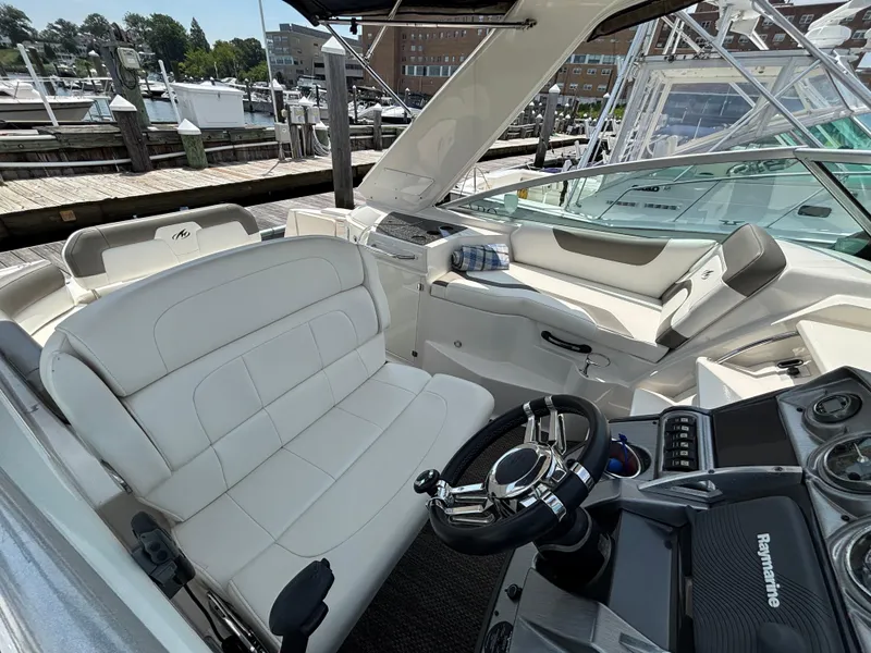 Slide: The Image of Interior of a 2013 Monterey 280 SCR boat with white seating and modern dashboard. - 7