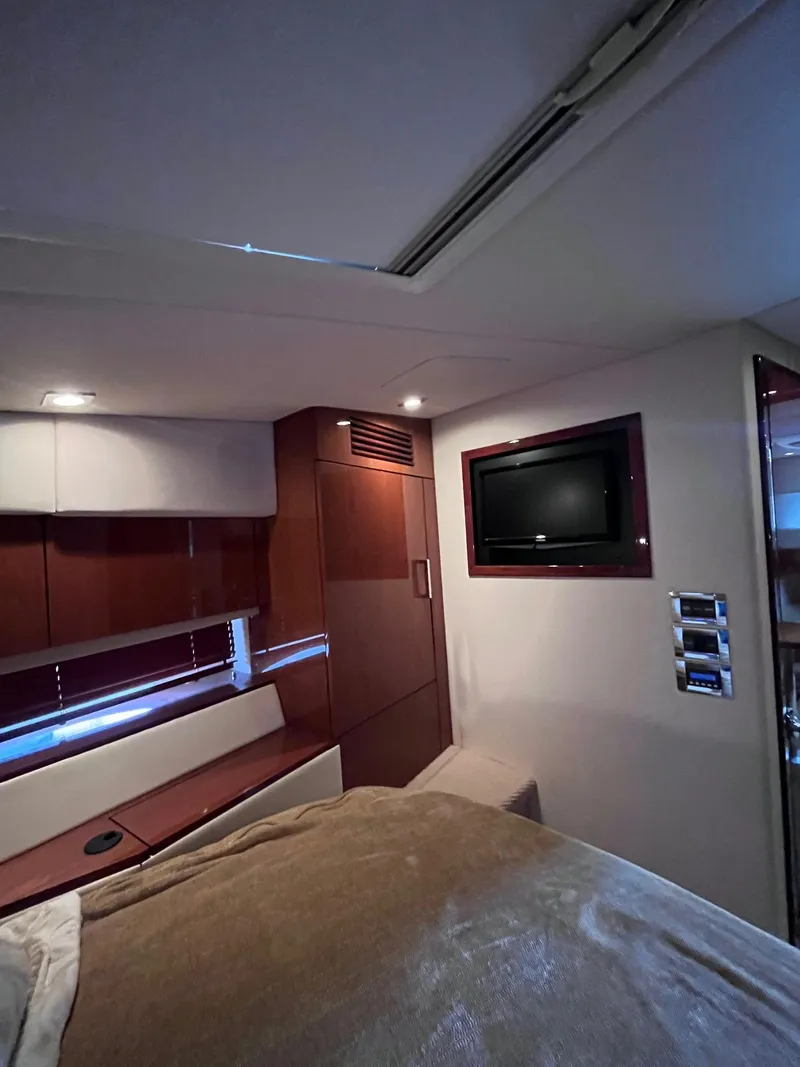 Slide: The Image of Interior cabin of 2013 Sea Ray 450 Sundancer yacht with TV and wood paneling. - 12