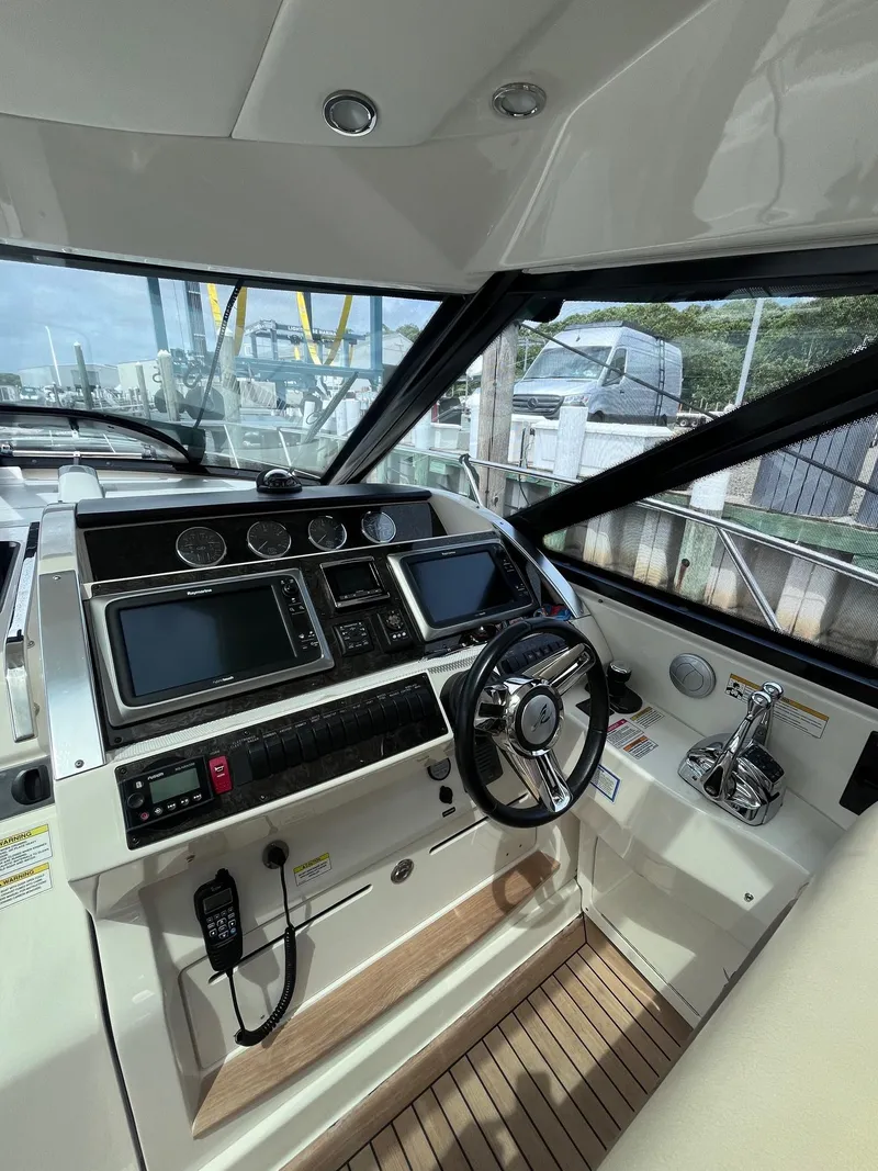 Slide: The Image of 2013 Sea Ray 450 Sundancer helm with modern controls and navigation systems. - 18
