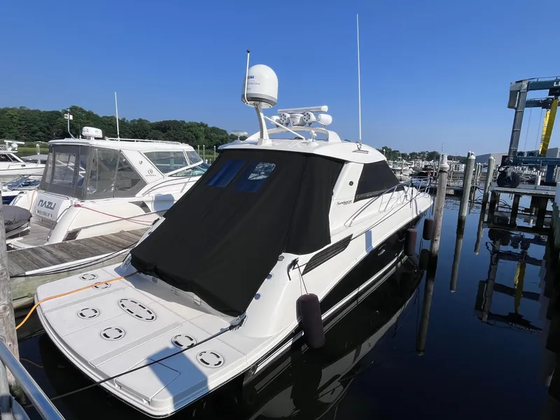 Slide: The Image of 2013 Sea Ray 450 Sundancer yacht docked at marina under clear blue sky. - 2