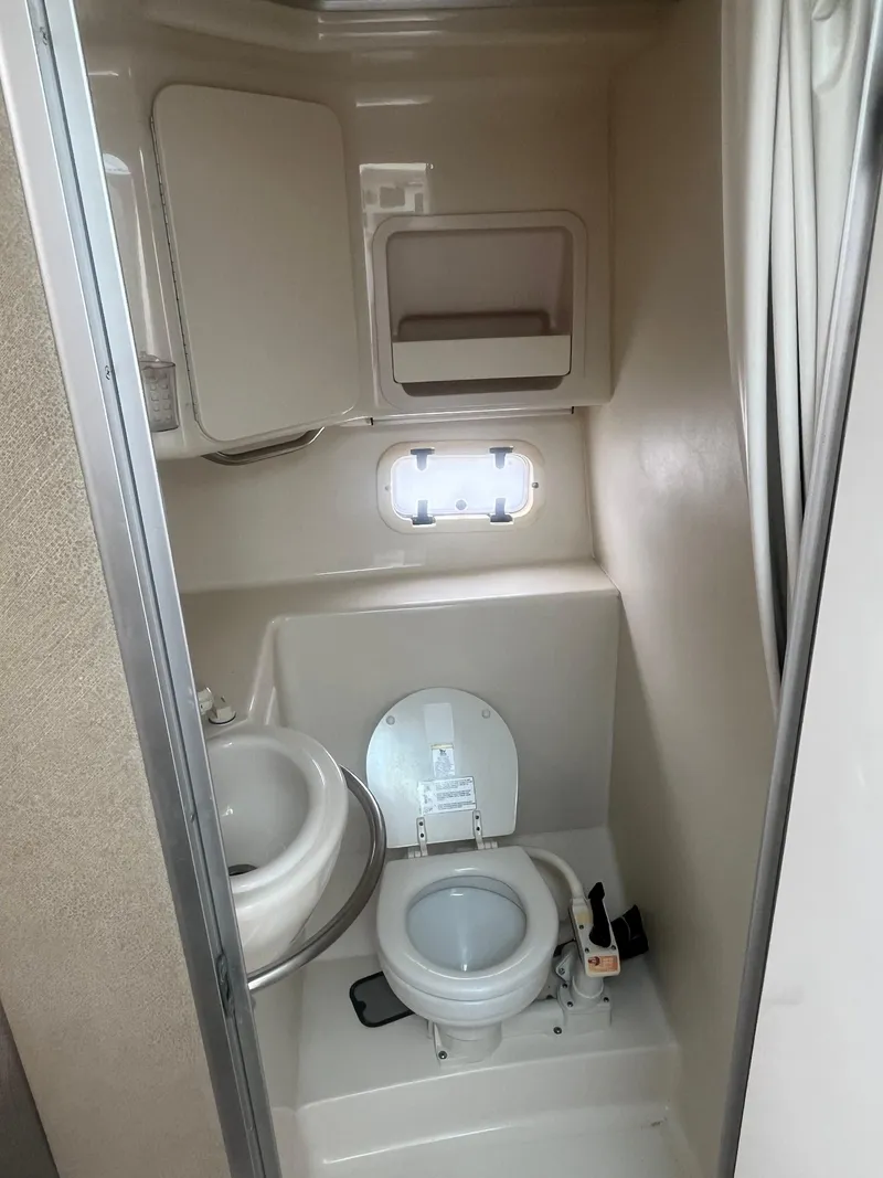 Slide: The Image of 1996 Maxum 2700 SCR boat bathroom with toilet, sink, and storage cabinet. - 10