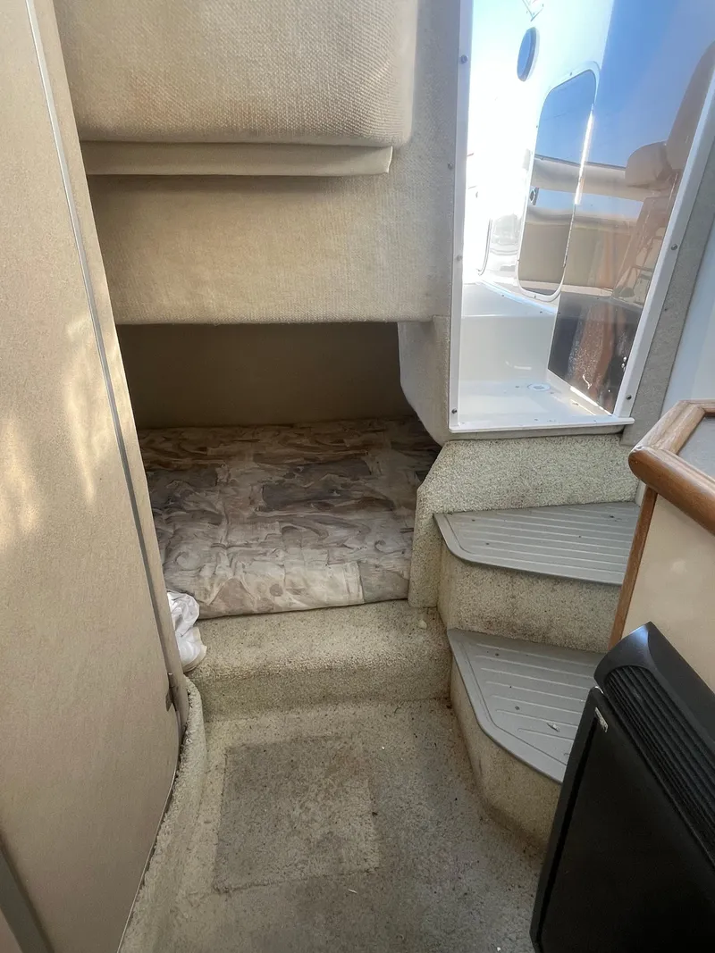 Slide: The Image of Interior cabin view of a 1996 Maxum 2700 SCR boat, featuring steps and a sleeping area. - 11