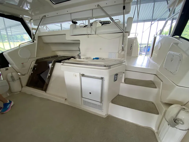 Slide: The Image of 1997 Silverton 372 Motor Yacht interior with steps, kitchenette, and seating area. - 10
