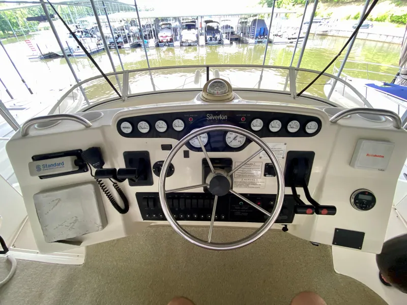 Slide: The Image of 1997 Silverton 372 Motor Yacht helm with steering wheel and control panel. - 16
