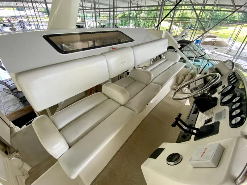 Slide: The Image of 1997 Silverton 372 Motor Yacht helm with white seating and control panel. - 17