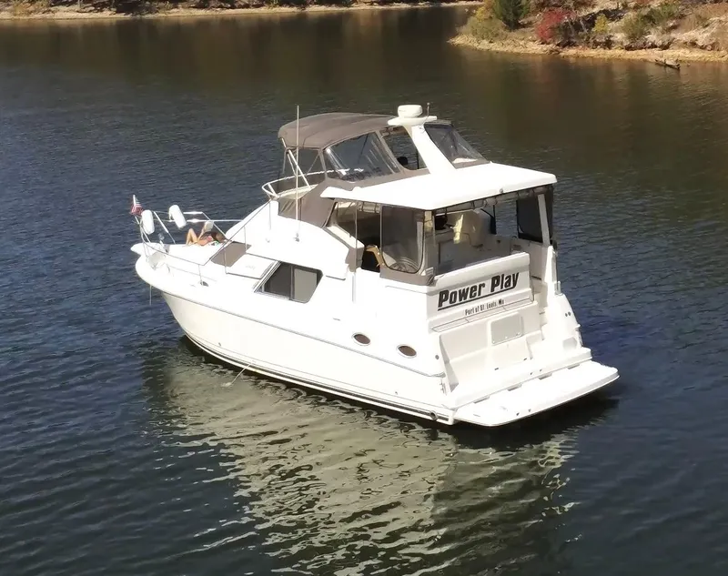 Slide: The Image of 1997 Silverton 372 Motor Yacht on calm water, featuring "Power Play" name on the stern. - 2