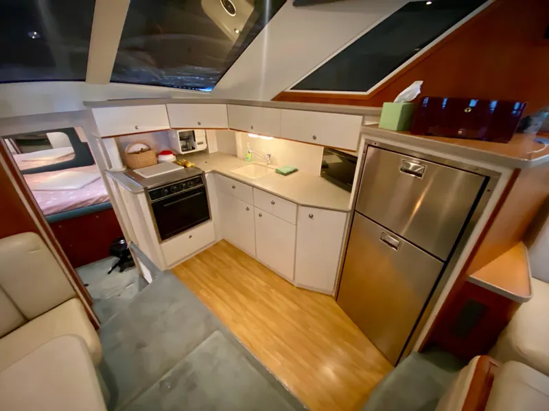 Slide: The Image of 1997 Silverton 372 Motor Yacht interior kitchen with modern appliances and wood flooring. - 25
