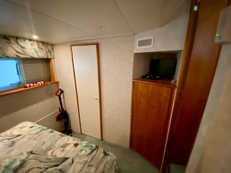 Slide: The Image of Interior of 1997 Silverton 372 Motor Yacht bedroom with bed, window, and storage. - 29