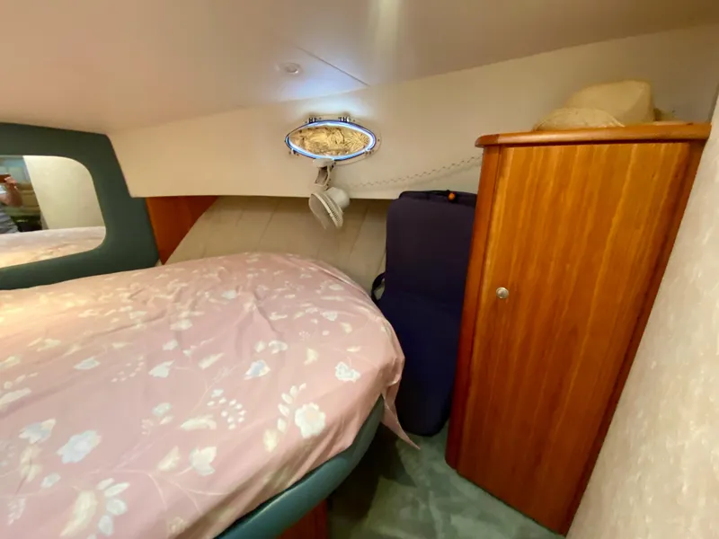 Slide: The Image of Cozy bedroom interior of 1997 Silverton 372 Motor Yacht with floral bedding and wooden cabinet. - 33