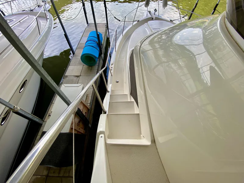 Slide: The Image of 1997 Silverton 372 Motor Yacht docked, showing side deck and railing. - 7