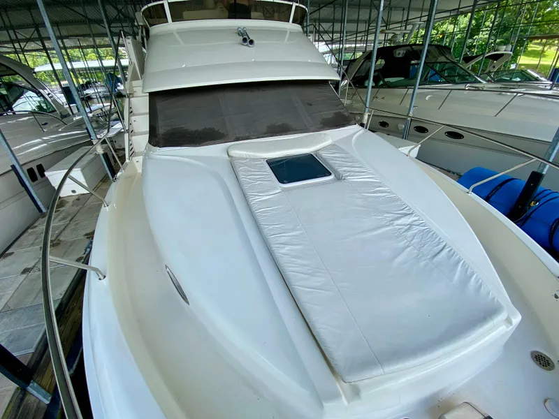 Slide: The Image of 1997 Silverton 372 Motor Yacht in marina, featuring sleek design and spacious deck. - 8