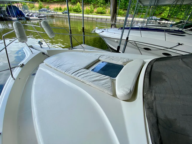 Slide: The Image of 1997 Silverton 372 Motor Yacht docked, featuring a spacious sunbathing deck. - 9