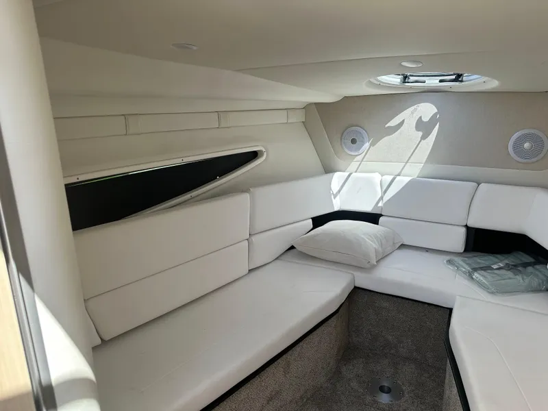 Slide: The Image of 2024 Regal 26 XO boat interior with white seating and circular window. - 14