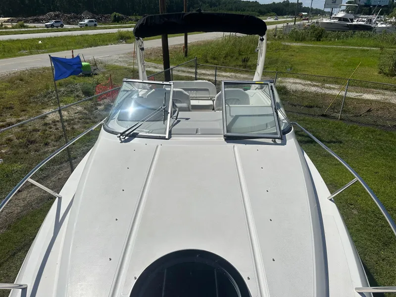 Slide: The Image of 2024 Regal 26 XO boat deck with open windshield, parked outdoors. - 15