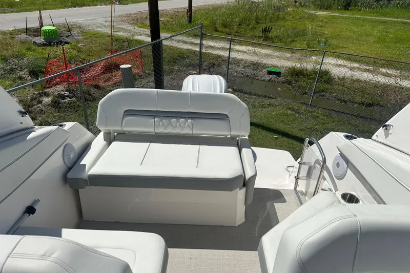 Slide: The Image of 2024 Regal 26 XO boat interior with white seating and outdoor view. - 19