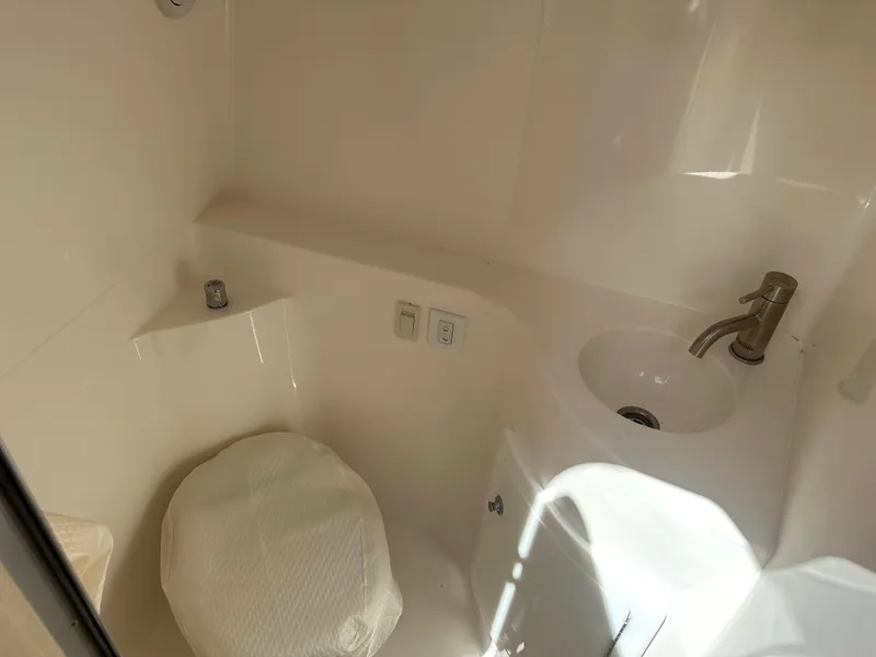 Slide: The Image of 2024 Regal 26 XO boat bathroom with sink and toilet, compact and modern design. - 22