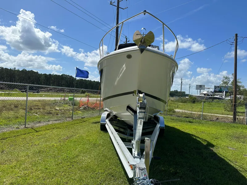 Slide: The Image of 2024 Regal 26 XO boat on trailer, parked on grass under a clear blue sky. - 3