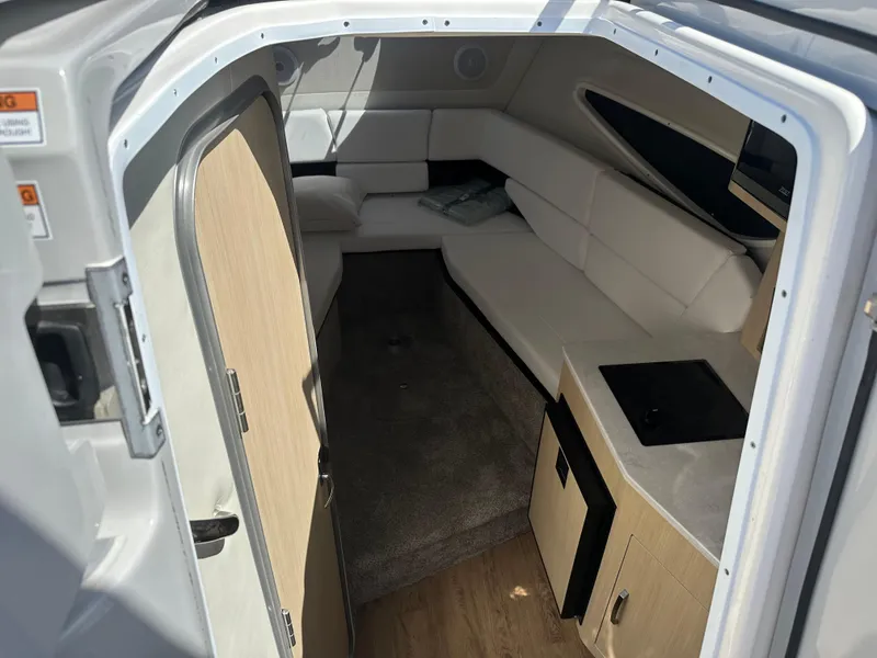 Slide: The Image of 2024 Regal 26 XO cabin interior with seating, kitchenette, and modern design. - 9
