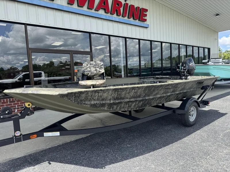 Slide: The Image of 2026 Tracker Grizzly 1654 T Sportsman boat on trailer outside marine store. - 10
