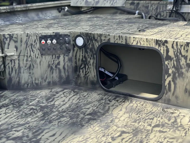 Slide: The Image of 2026 Tracker Grizzly 1654 T Sportsman boat interior with camouflage design and control panel. - 13
