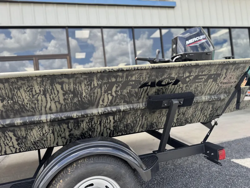 Slide: The Image of 2026 Tracker Grizzly 1654 T Sportsman boat with camouflage design and Mercury engine. - 4