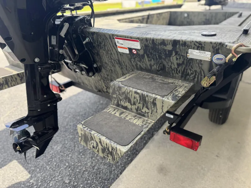 Slide: The Image of 2026 Tracker Grizzly 1654 T Sportsman boat rear view with motor and camouflage design. - 6