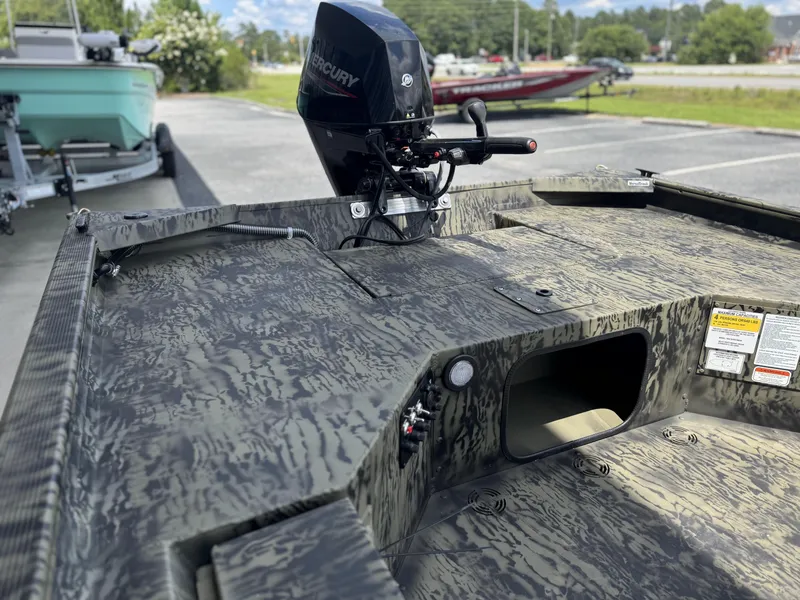 Slide: The Image of 2026 Tracker Grizzly 1654 T Sportsman boat with camouflage design and Mercury outboard motor. - 7