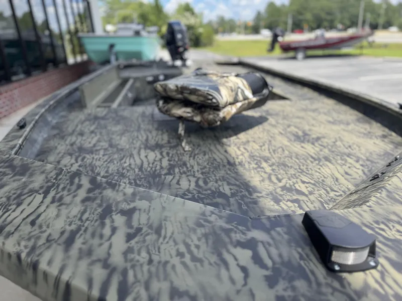 Slide: The Image of 2026 Tracker Grizzly 1654 T Sportsman boat with camouflage pattern, parked outdoors. - 8