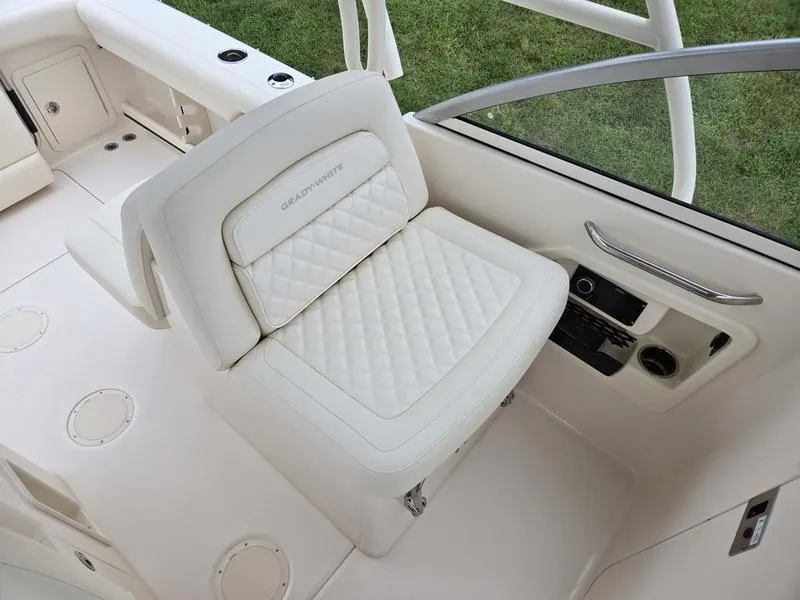 Slide: The Image of 2026 Grady-White Freedom 255 boat interior with white cushioned seating. - 13