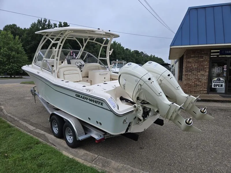 Slide: The Image of 2026 Grady-White Freedom 255 boat on trailer, parked near a building. - 9