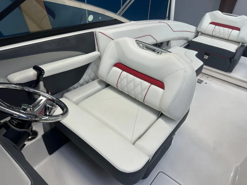 Slide: The Image of 2022 Regal LX4 boat interior with white and red seating, steering wheel, and modern design. - 11