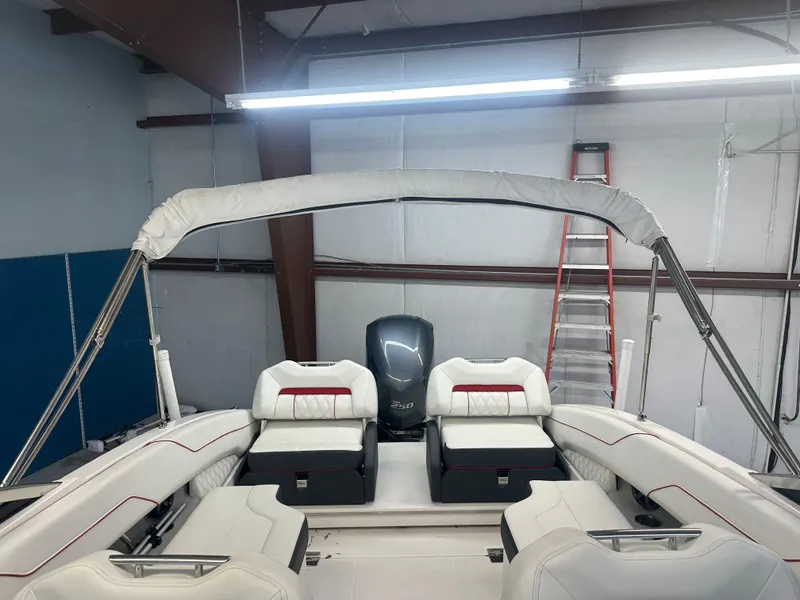 Slide: The Image of 2022 Regal LX4 boat interior with white seating and canopy in a garage setting. - 13