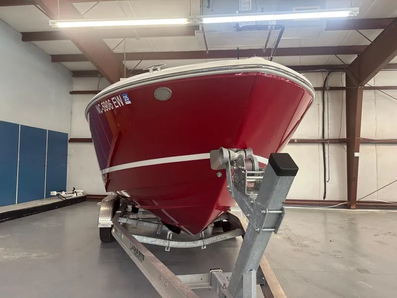 Slide: The Image of 2022 Regal LX4 boat in storage, red hull on trailer. - 2
