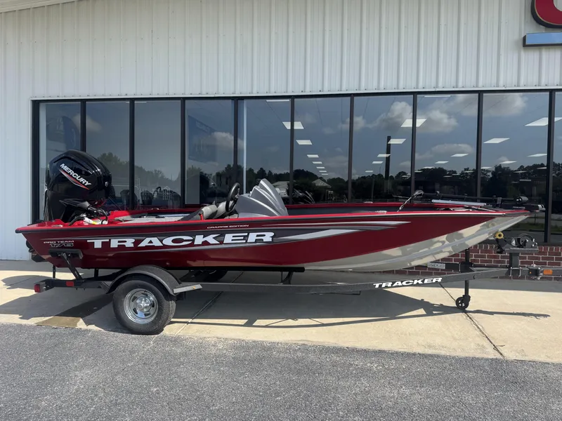 The Image of 2026 Tracker Pro Team 175 Crappie Edition boat, red and silver, parked outside a building. - 0