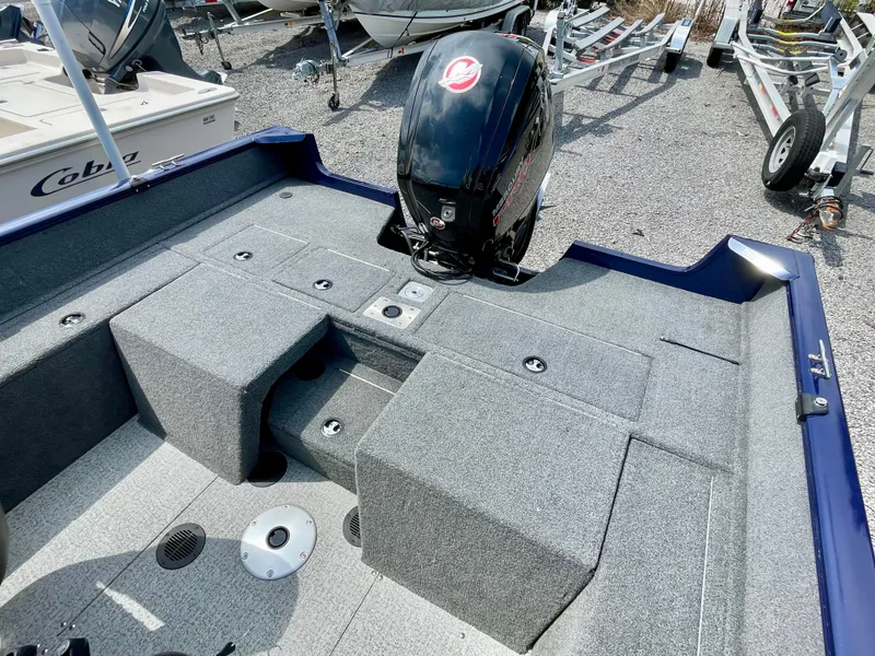 Slide: The Image of 2020 Tracker Pro Guide V-175 Combo boat interior with motor, parked on gravel. - 16