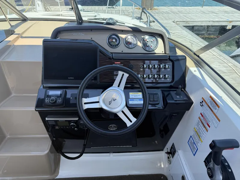 Slide: The Image of 2017 Sea Ray Sundancer 280 helm with steering wheel, gauges, and navigation controls. - 10