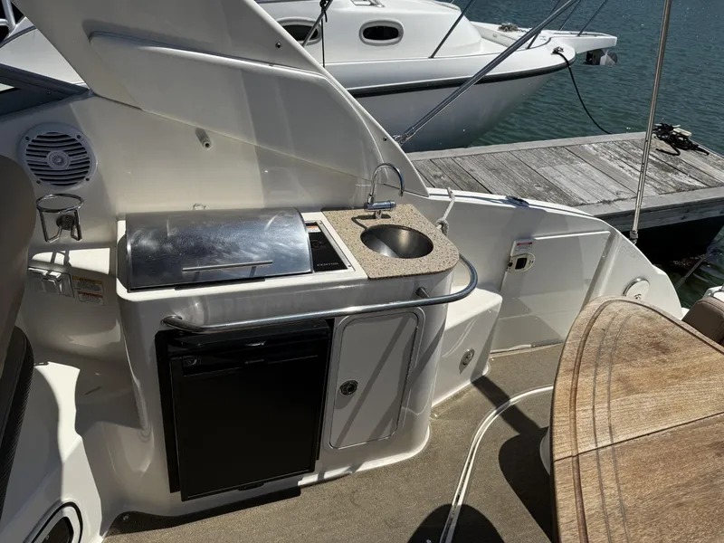 Slide: The Image of 2017 Sea Ray Sundancer 280 boat kitchenette with sink, grill, and mini fridge. - 13
