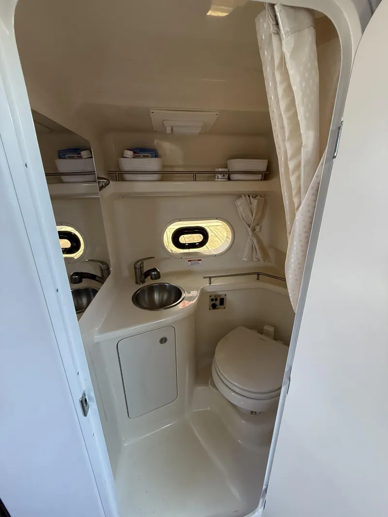 Slide: The Image of 2017 Sea Ray Sundancer 280 bathroom with sink, toilet, and porthole window. - 17